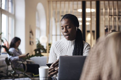 Young woman using digital tablet at office