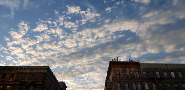 Low angle view of buildings against cloudy sky