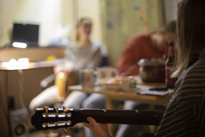 Midsection of man playing guitar