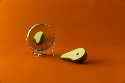 Pear and mirror against red background