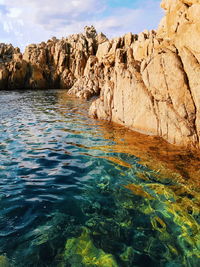 Rock formation in sea against sky