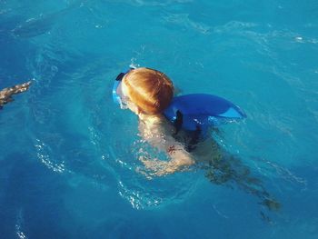 High angle view of boy swimming in sea