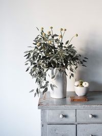 High angle view of flower vase by food in bowl on table