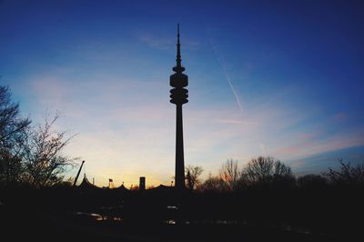 Silhouette of communications tower against sky during sunset