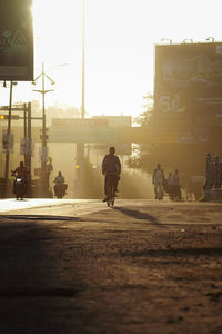 Beautiful morning empty road with sun rays on road, people going to work, people on street 