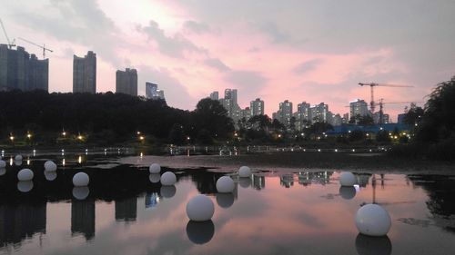 Reflection of illuminated buildings in lake at sunset