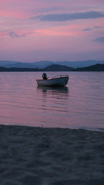 Boat on sea against sky during sunset