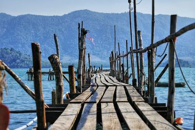 Wooden pier over sea against sky