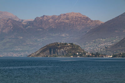 Scenic view of sea and mountains against clear sky