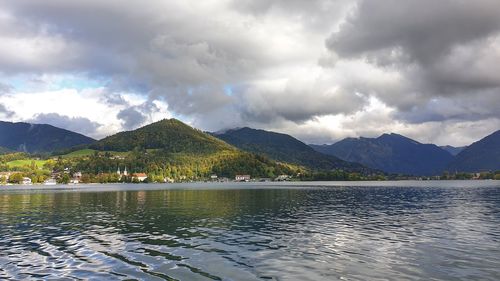 Scenic view of lake by mountains against sky