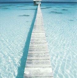 Close-up of boardwalk at shore against sky