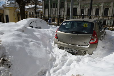 Car on snow covered buildings in city