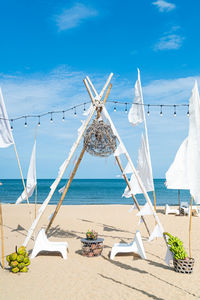 Traditional windmill on beach against blue sky