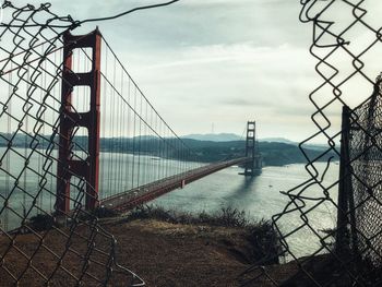 View of suspension bridge against cloudy sky