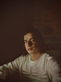 Portrait of young man against black background