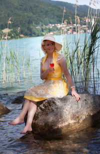 Portrait of woman sitting on rock