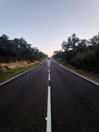 Man standing on road against sky