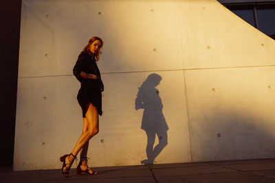 Side view of woman walking on footpath