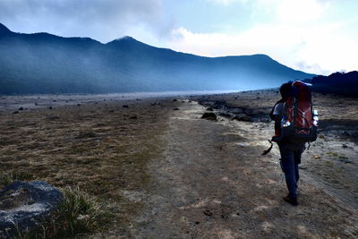 Full length of man walking on mountain against sky