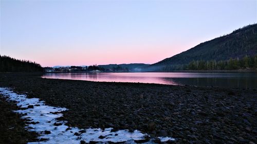 Scenic view of lake against clear sky during sunset