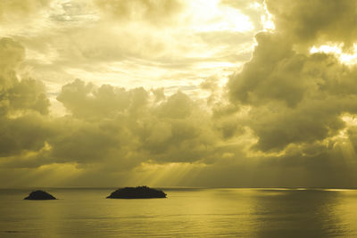 Scenic view of sea against cloudy sky at sunset