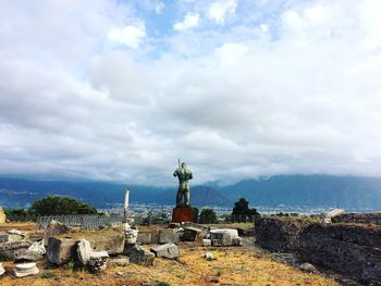 Statue of historic building against cloudy sky