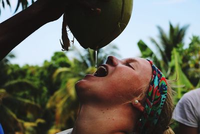 Close-up of young woman against trees