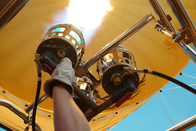 Low angle view of hand steering a flying hot air balloon