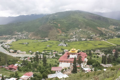 Scenic view of village and mountains against sky