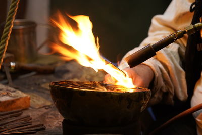 Close up of hands of man doing traditional handwork for heating metall with fire