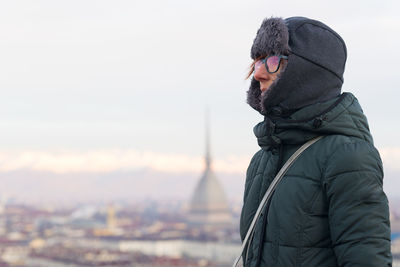 Woman wearing winter coat with mole antonelliana in background