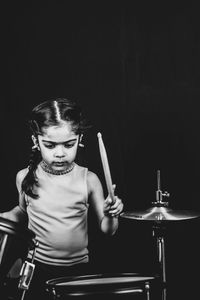 High angle view of girl playing musical instrument against black background