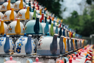 Close-up of multi colored teapots in row at market
