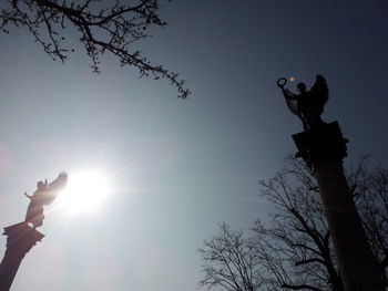 Low angle view of sun shining through clouds