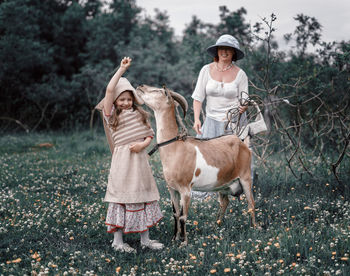 Family standing on field against trees