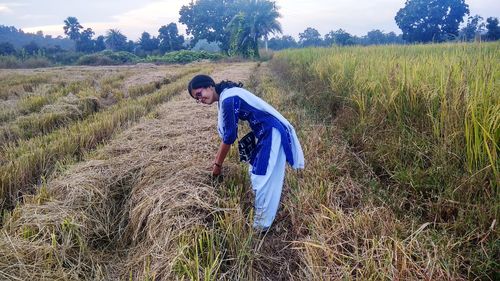 Portrait of young woman standing on agricultural field