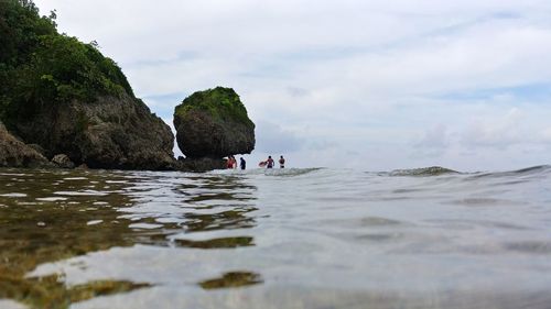 Scenic view of rocks in sea against sky