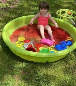 Cute girl playing with toy in grass