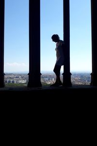 Side view of man looking through window