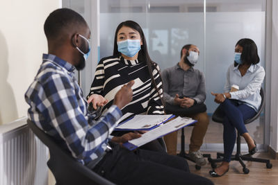 Interviewer wearing mask talking with candidate in office