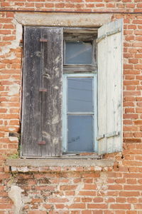 Low angle view of window on brick wall of building