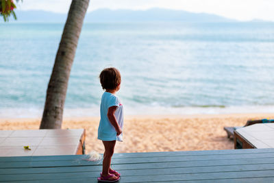 Rear view of boy at beach