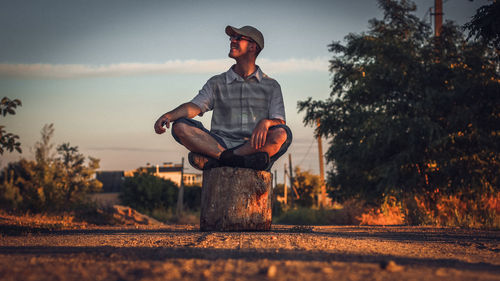 Man standing by tree against sky