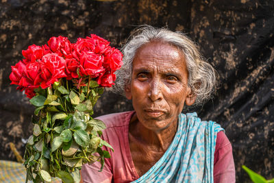 Close-up portrait of woman with red roses