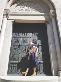 Full length of woman standing against building