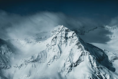 Snow covered mountain peaks reaching above a sea of clouds, gastein, austria