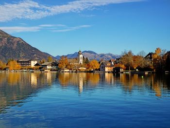 Scenic view of lake by buildings against sky