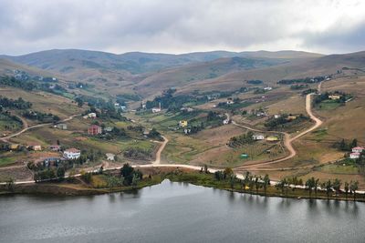 Scenic view of river and mountains against sky