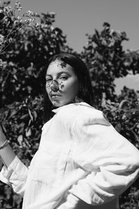 Portrait of woman standing against plants