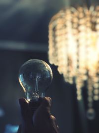 Close-up of hand holding light bulb
